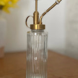 Clear glass bottle with brass pump on a wooden surface