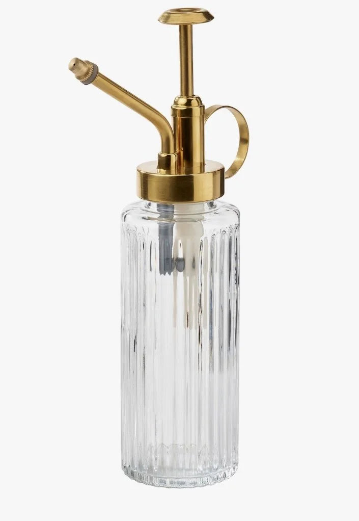 Clear glass bottle with gold metal nozzle on a white background
