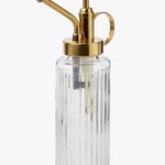 Clear glass bottle with gold metal nozzle on a white background
