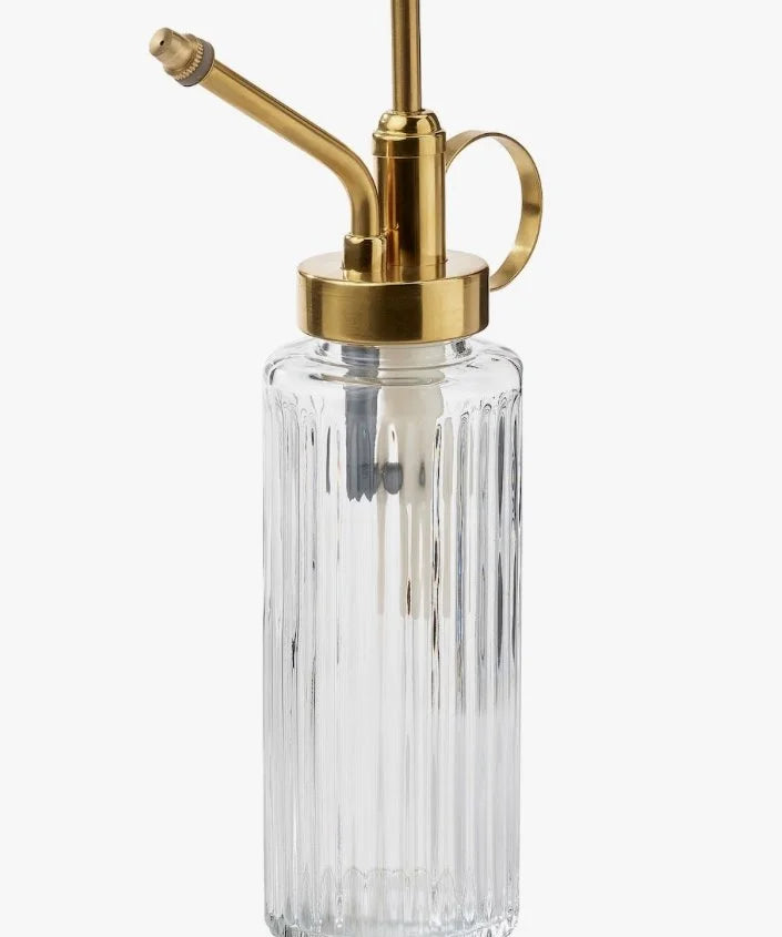 Clear glass bottle with gold metal nozzle on a white background