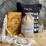 Mushroom growing kit with book, grow bag, and other items on a wooden surface.