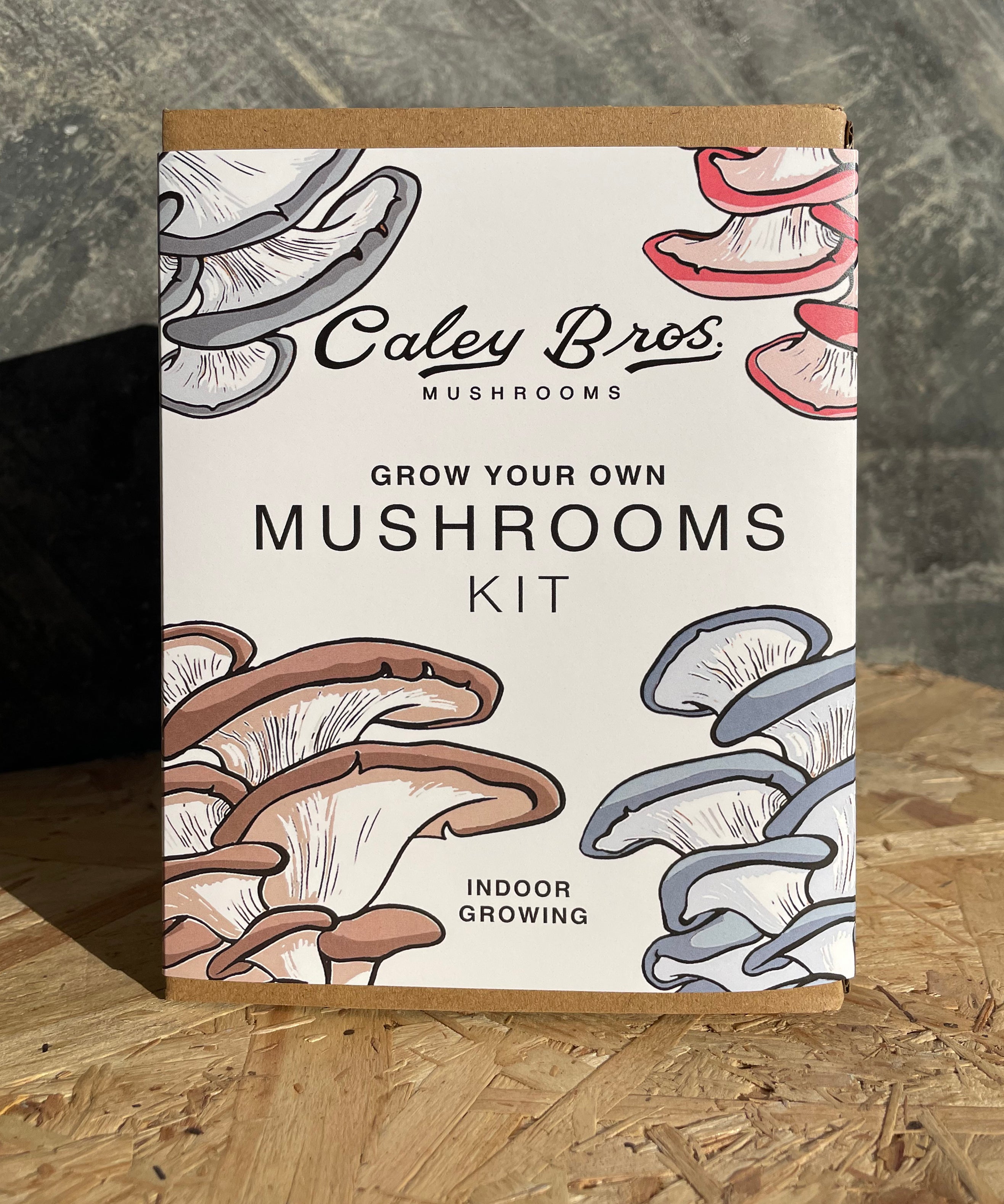 Caley Bros mushroom growing kit packaging with illustrations of mushrooms on a wooden surface.