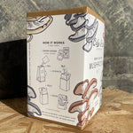 Mushroom kit packaging with illustrations and text on a wooden surface